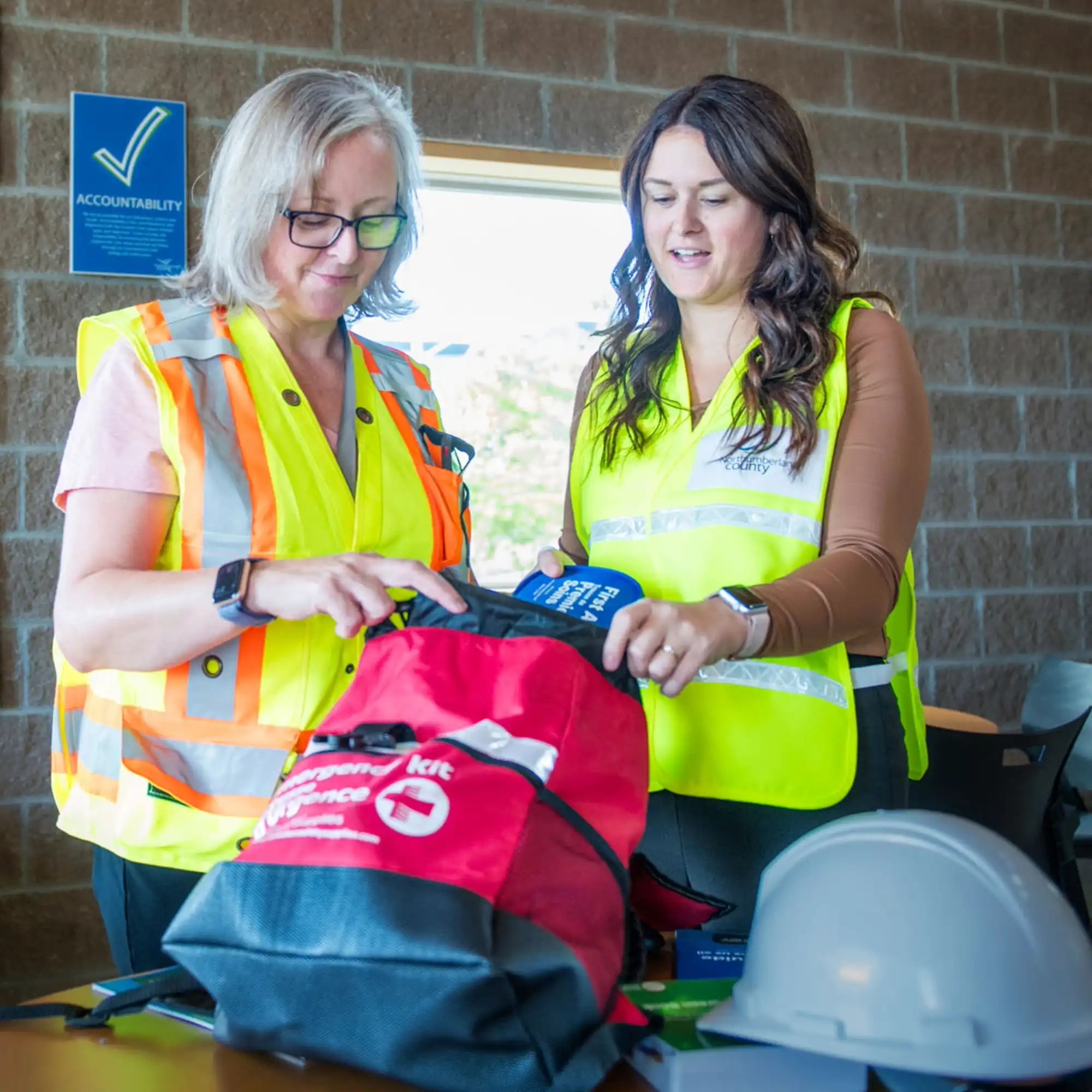 Two County staff member assembling an emergency preparedness kit 