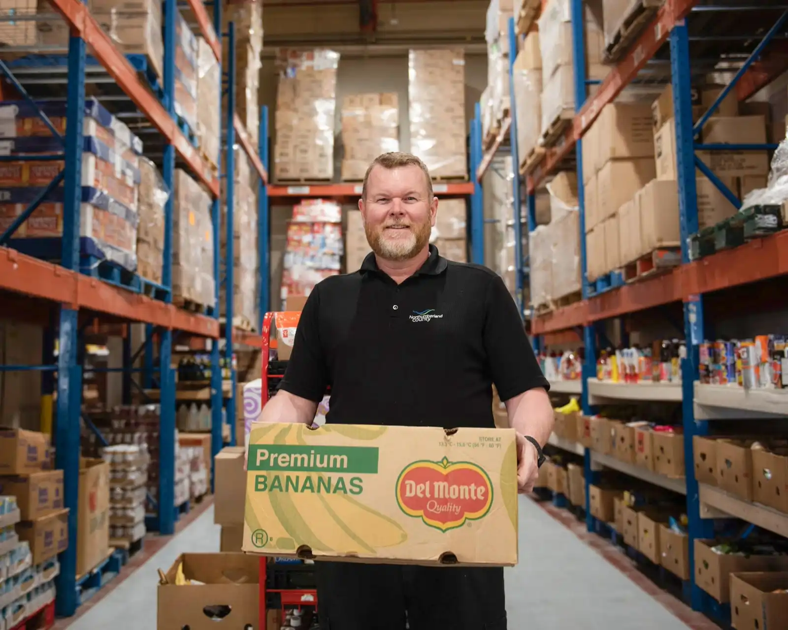 Northumberland County staff member holding a box in the Food 4 All Warehouse 