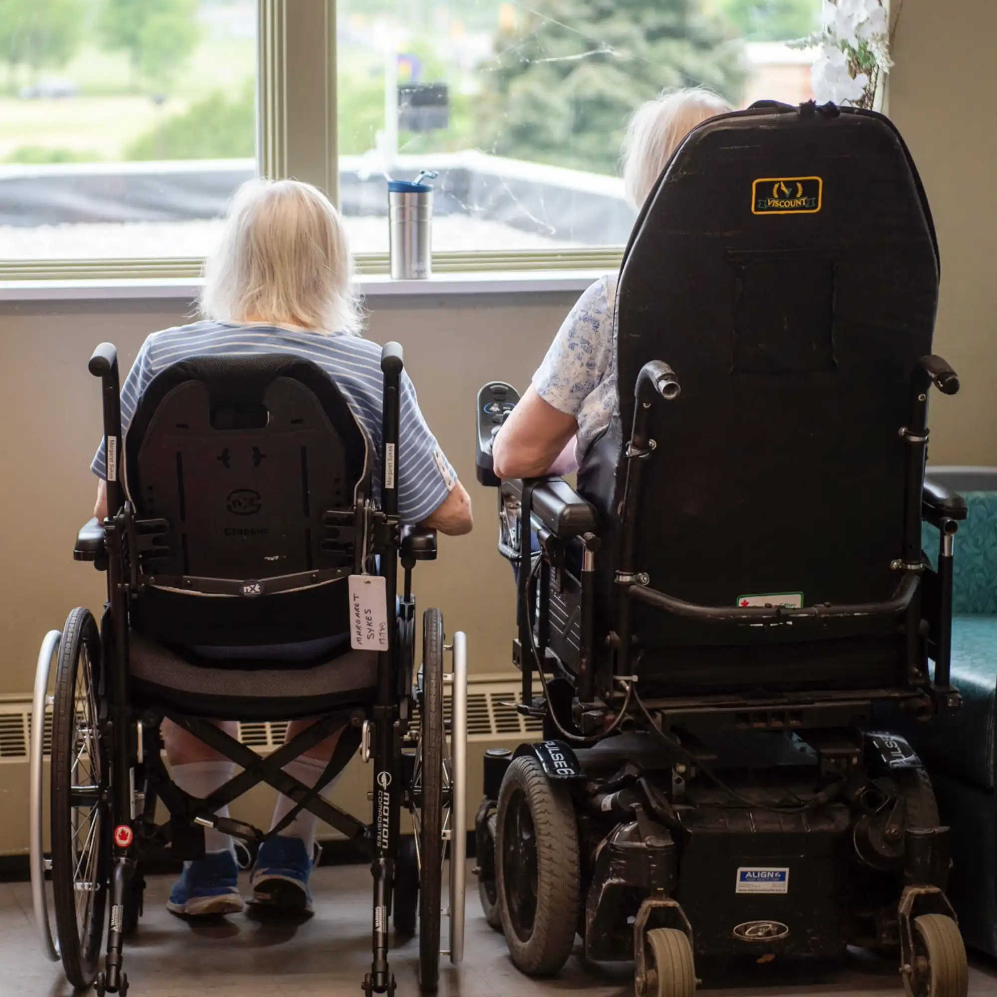 Two residents at the GPPL sitting looking out a window. 