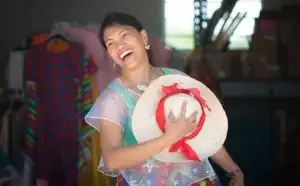 Lady laughing and holding hat