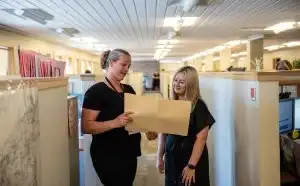 Two Community Services and Support employees looking at a file 