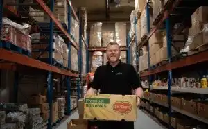 A Food 4 All worker holds a box of food 
