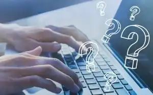 A person's hands typing on a computer keyboard